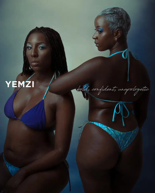 two black models wearing blue bikinis against an ombre backdrop