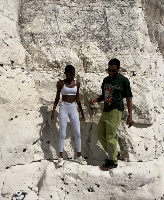 female black model and male assistant posing in front of a rock