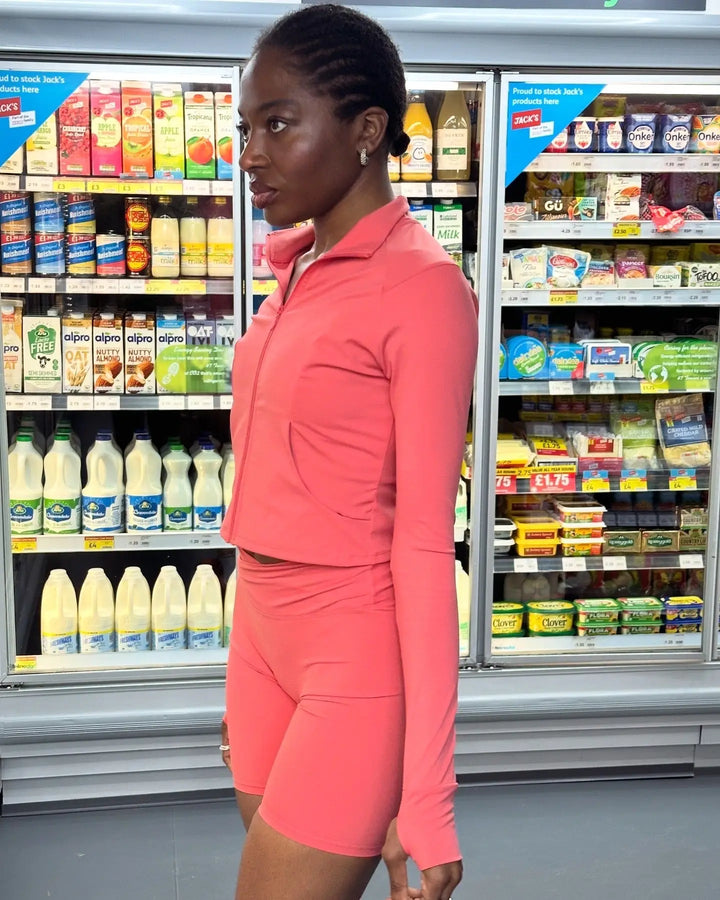yem akingbade in a corner store wearing the guava shade activewear set