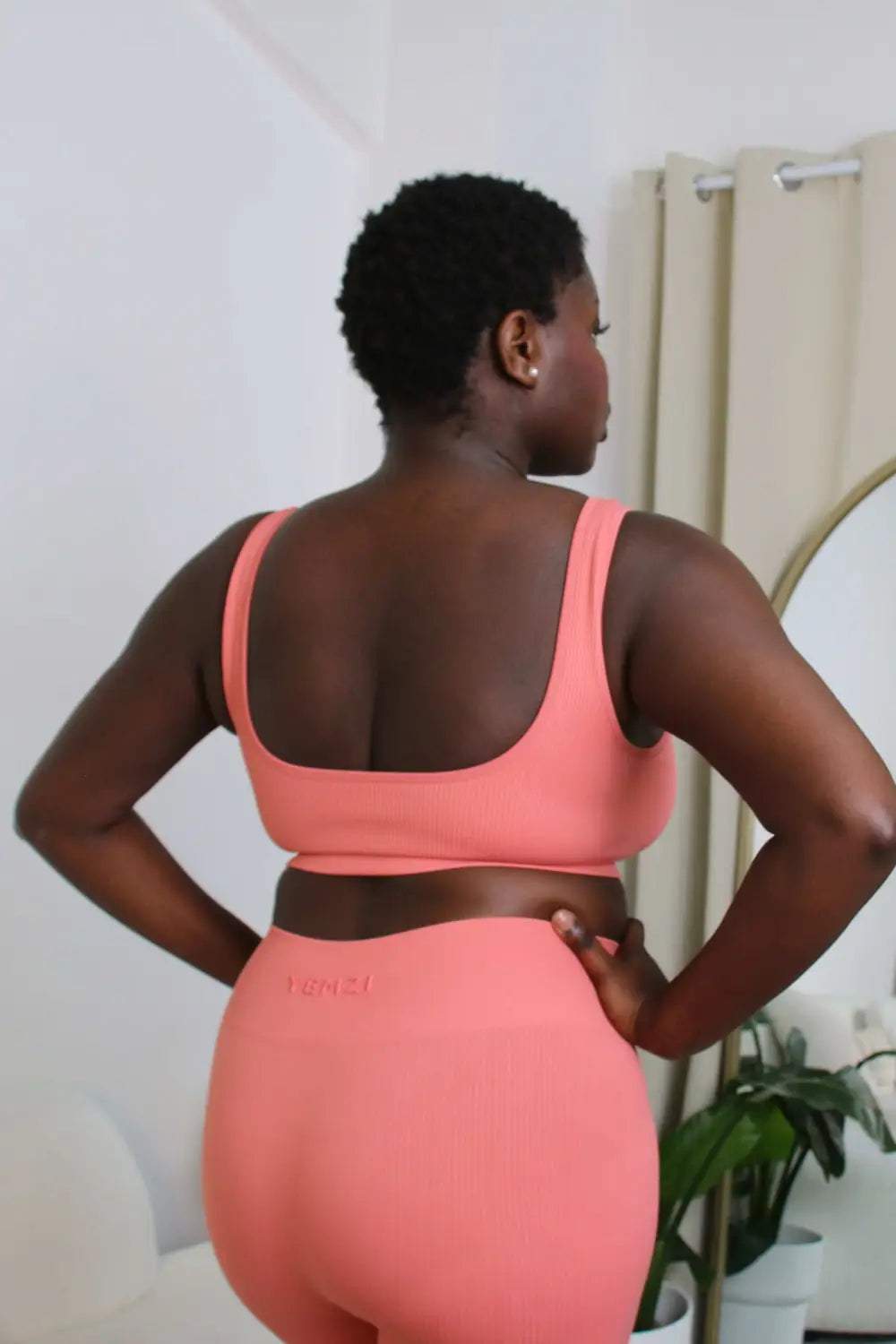 African model wearing the yemzi guava pink seamless ribbed bra and legging set