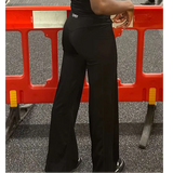 Tall contour black pants worn by a lady in the gym 