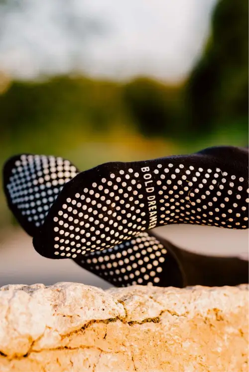 Black grip socks with white dots on a blurred natural background