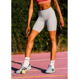 Person wearing sky blue athletic shorts and grace wales bonner Adidas trainers