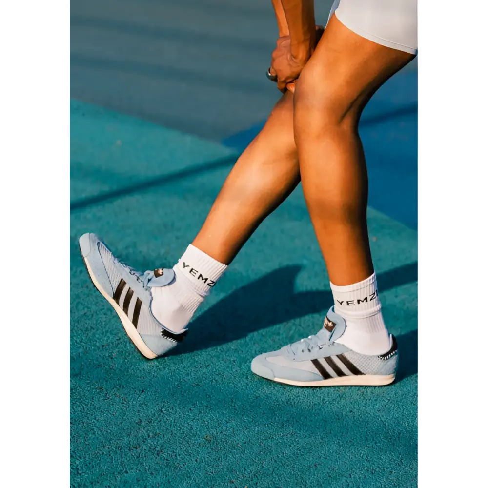 black model wearing light blue grace wales bonner Adidas sneakers with white socks on a tennis court.