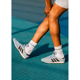 black model wearing light blue grace wales bonner Adidas sneakers with white socks on a tennis court.