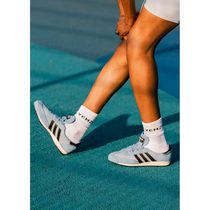 black model wearing light blue grace wales bonner Adidas sneakers with white socks on a tennis court.
