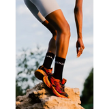 african model wearing puma shoes and yemzi socks on a rock with a blurred natural background