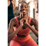 Woman in pink athletic wear smiling outdoors