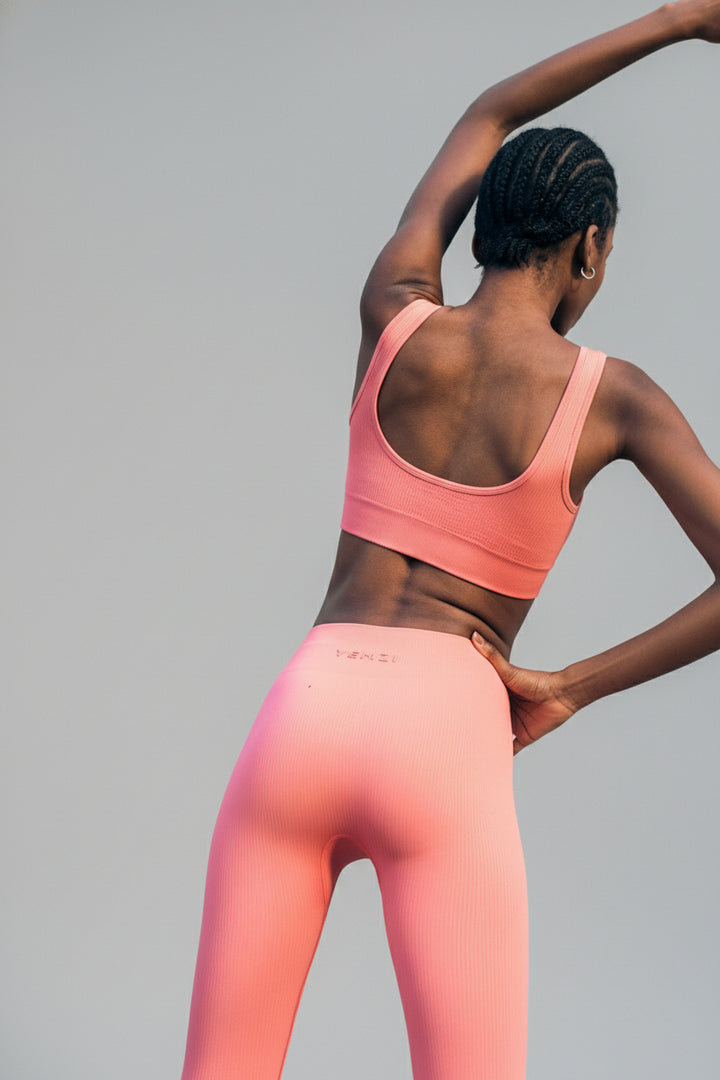 Two women in pink athletic wear standing on stone steps.
