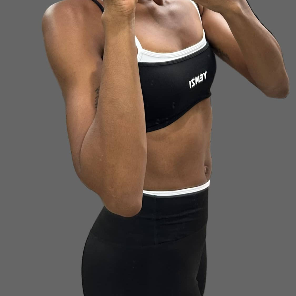 Person wearing a black sports bra with a brand logo in a store setting