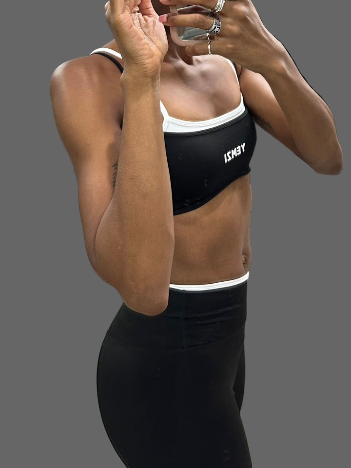 Person wearing a black sports bra with a brand logo in a store setting