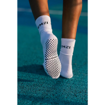 White bold dreamer grip socks with black text on a tennis court