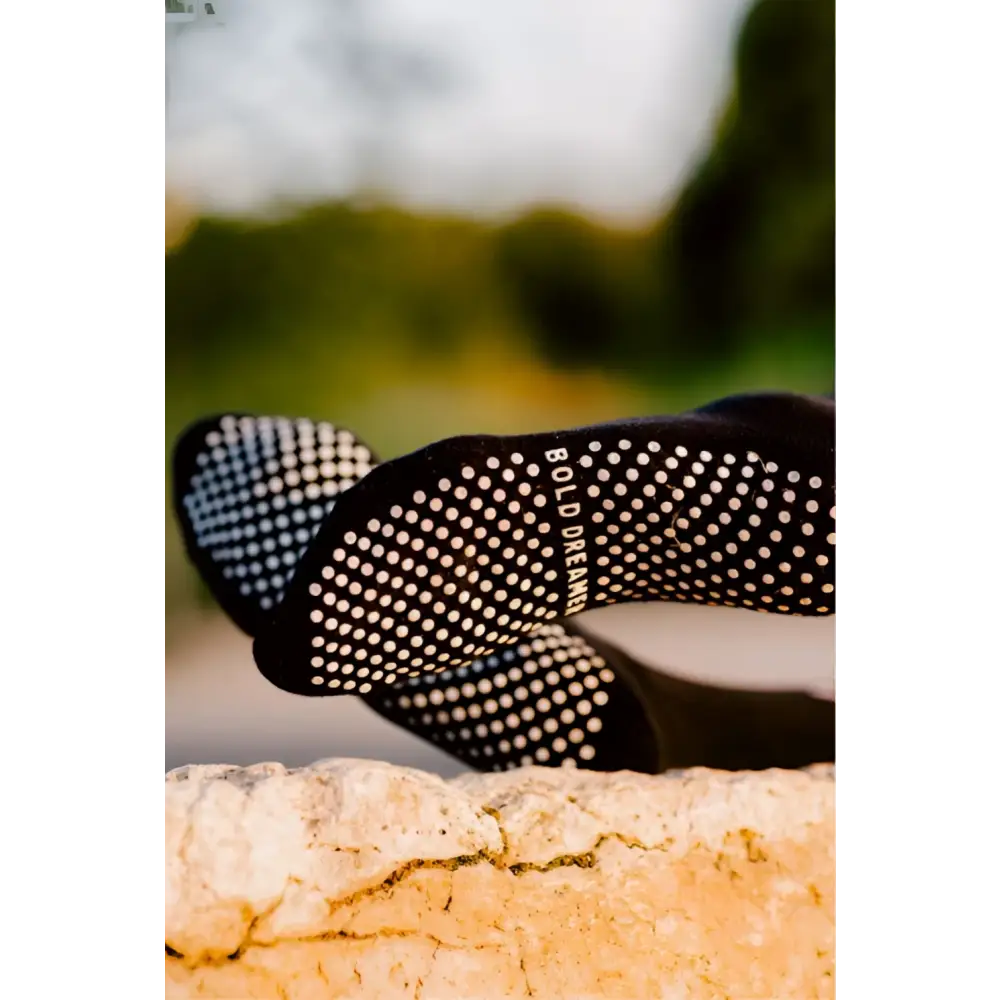 Black grip socks with white dots on a blurred natural background