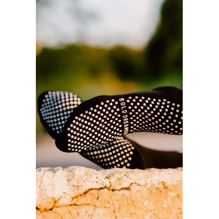 Black grip socks with white dots on a blurred natural background