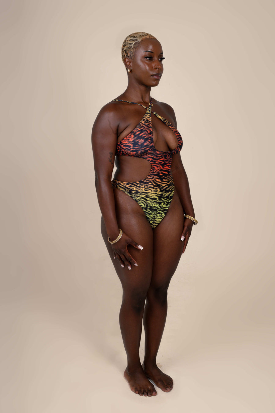 Woman wearing a colorful halter neck swimsuit on a beige background