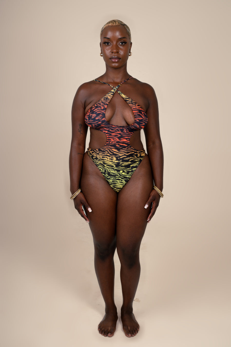 Woman wearing a colorful animal print bikini against a beige background